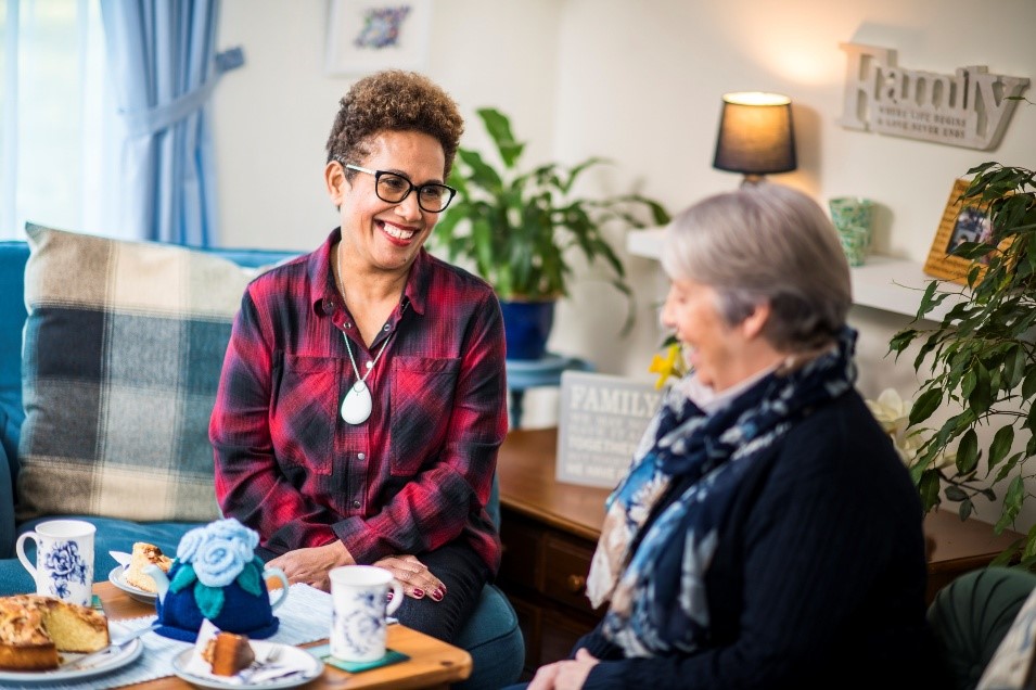 Two ladies sat down taking tea